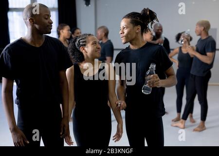 Des danseurs modernes de course mixtes parlent ensemble dans un studio Banque D'Images