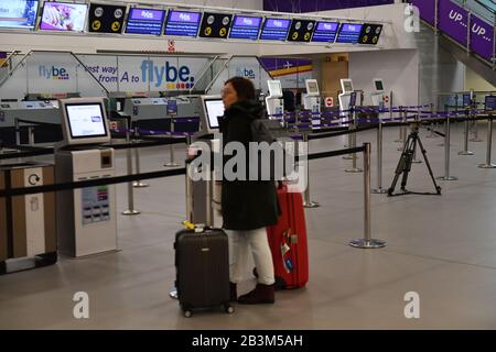 Un passager regarde les comptoirs d'enregistrement vides de l'aéroport international de Birmingham car Flybe, la plus grande compagnie aérienne régionale d'Europe, s'est effondré en administration. Banque D'Images