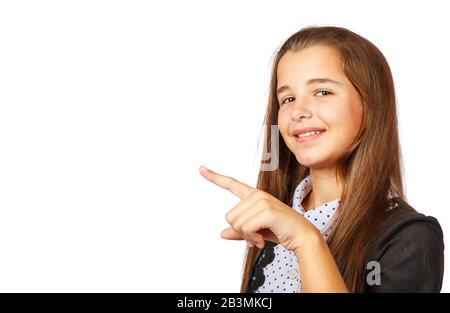 une jeune fille positive de brunette montrant un produit. belle fille de l'adolescence de brunette avec de longs cheveux pointant vers le côté . présentant votre produit. isolé sur Banque D'Images