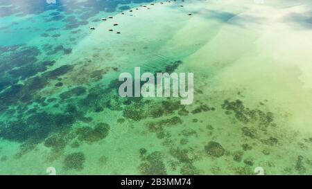 Un cottage flottant sur un sandbar dans l'île touristique de Caramoan aux Philippines. Un lagon avec des crottes flottantes, vue sur le dessus. Surface de la mer avec des cottages en bambou. Concept de vacances d'été et de voyage. Banque D'Images