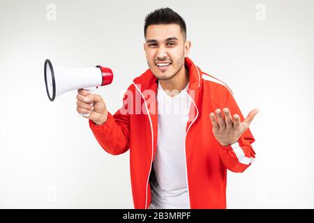 portrait d'un jeune homme avec un haut-parleur dans ses mains sur un fond de studio blanc Banque D'Images
