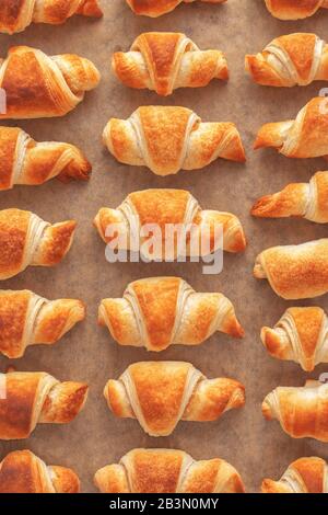 Plat posez des croissants de pâte feuilletée dorés fraîchement cuits avec de la confiture sur du papier de cuisson. Banque D'Images