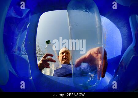 homme mettant des bouteilles en plastique dans la circonscription est du yorkshire recyclage wheie bin ellerton yorkshire royaume-uni Banque D'Images