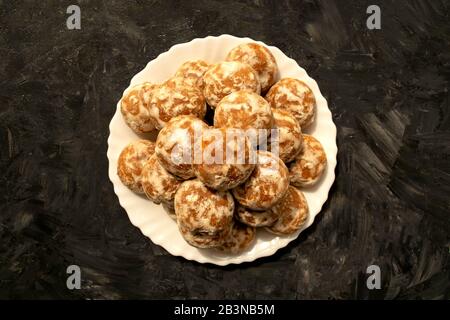 Célèbre pain d'épice russe sur plaque blanche sur fond rustique gris. Un tas de pain d'épice russe glacé rond. Gâteaux au miel Banque D'Images