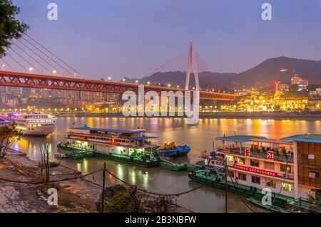 Vue sur le pont Masangxi et les bateaux de croisière sur le fleuve Yangtze au crépuscule, dans le district de Yuzhong, à Chongqing, en Chine, en Asie Banque D'Images