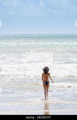 Une jeune femme qui s'ingérer dans l'Atlantique tropical, l'île Morro de Sao Paulo, Bahia, Brésil, Amérique du Sud Banque D'Images