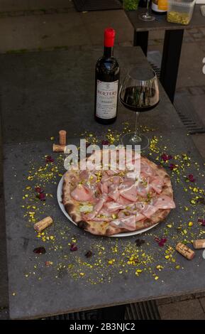 La mortadella rustique a surmonté la pizza avec du vin rouge au restaurant italien Banque D'Images