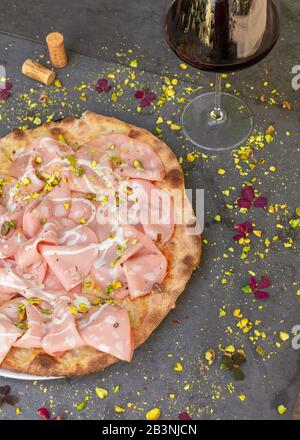 La mortadella rustique a surmonté la pizza avec du vin rouge au restaurant italien Banque D'Images