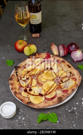 Pizza rustique avec pomme et vinaigre balsamique de style oignon rouge au restaurant italien Banque D'Images