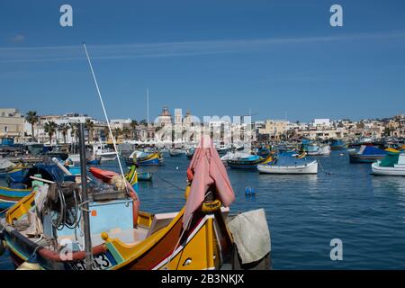 Marsaxlok Malte 9 février 2020: Village maltais de pêcheurs de Marsaxlokk avec un gros plan de bateau peint traditionnel à Foreground Banque D'Images