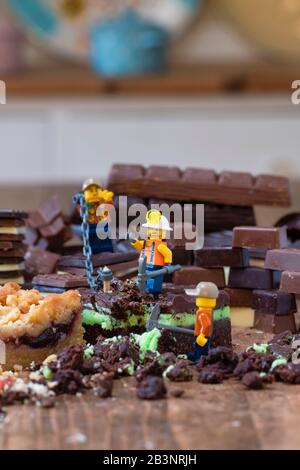 Extraction de chocolat et de gâteaux. Jouet Lego hommes avec gâteau et chocolat Banque D'Images