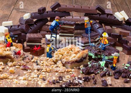 Extraction de chocolat et de gâteaux. Jouet Lego hommes avec gâteau et chocolat Banque D'Images