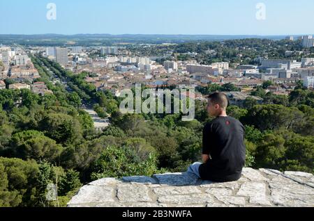 Jeune Homme Bénéficiant D'Une Vue Panoramique Sur Nîmes Depuis La Tour Romaine Ou Visite De Magne Avec L'Avenue Jean Jaurès Nîmes Gard France Banque D'Images