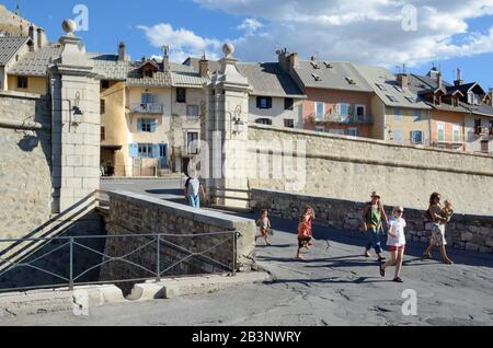 Touristes en famille devant la porte Dauphine dans la ville fortifiée de Briançon, Hautes-Alpes, France, conçue par Vauban Banque D'Images