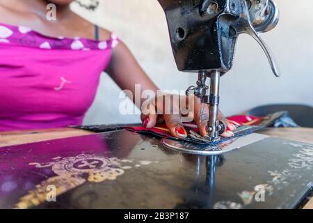 Couturière utilisant sa machine à coudre noire pour faire des robes africaines au Mozambique Banque D'Images