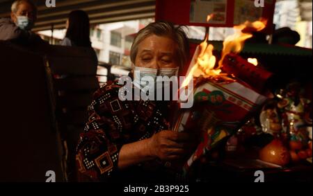 Hong Kong, CHINE. 5 mars 2020. Une Dame masquée, un chanteuse spirituelle, un soi-disant Villain Hitter exécute un rituel traditionnel de MÉCHANT FRAPPER en exorcisant les 'diabless' et 'malchance' pour les clients sur le bord de la route. Da SIU YAN ( Villain Frapper ) est un exorcisme populaire traditionnel chinois exécuté chaque année pendant le printemps Pour rejeter les "maux" et les "ennuis" qui est considéré par les Chinois pour contrarier le monde humain.Mar-5, 2020 Hong Kong.ZUMA/Liau Chung-ren crédit: Liau Chung-ren/ZUMA Wire/Alay Live News Banque D'Images