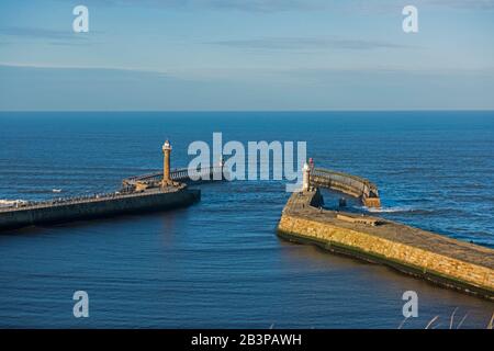 Vue aérienne de la petite entrée du port côtier avec des murs de défense et un phare Banque D'Images