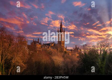 En regardant à travers les arbres pour les majestueuses Tours de l'université de Glasgow, en fin d'après-midi. Banque D'Images