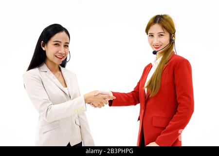 Deux opérateurs de centre d'appels asiatiques heureux se secouent l'un l'autre sur fond blanc. Banque D'Images
