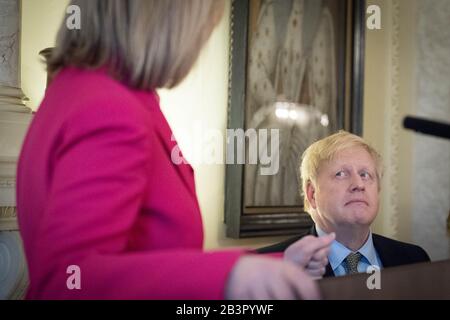 Le Premier ministre Boris Johnson écoute Liz Truss lors d'un événement de groupe et d'une réception pour marquer la Journée internationale de la femme à Downing Street à Westminster, Londres. Banque D'Images