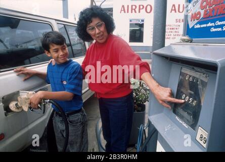 Austin, Texas Etats-Unis, 1989: Femme et fils remplissant 1983 Land Cruiser de gaz.© Bob Daemmrich Banque D'Images