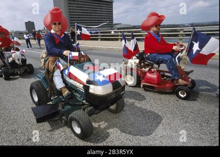 Austin, Texas, États-Unis, 02MAR00 : les hommes en chapeaux de cow-boy surdimensionnés s'assoient sur des tondeuses à gazon pendant qu'ils se dirigent vers Congress Avenue lors d'un défilé du Texas Independence Day jusqu'au Capitole de l'État.Le Texas a déclaré son indépendance du Mexique le 2 mars 1836.©Bob Daemmrich Banque D'Images