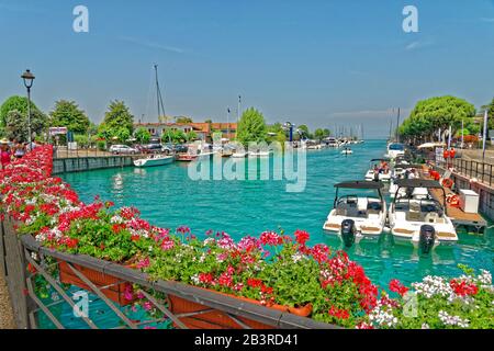 Quayside et la rivière Mincio qui coule du lac de Garde à Peschiera del Garda, Vénétie, Italie. Banque D'Images