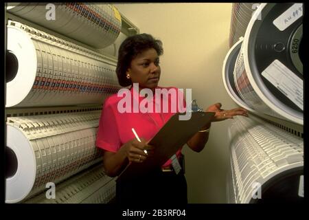 Austin Texas USA, 1990: Une employée noire examine des racks de bandes magnétiques stockant des données compilées au centre régional de traitement des données du recensement des États-Unis.©Bob Daemmrich Banque D'Images