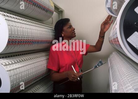 Austin Texas USA, 1990: Une employée noire examine des racks de bandes magnétiques stockant des données compilées au centre régional de traitement des données du recensement des États-Unis.©Bob Daemmrich Banque D'Images