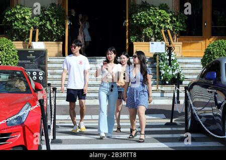 Monte-Carlo, Monaco - 20 Juin 2019: Groupe De Jeunes Touristes Asiatiques Devant Le Casino Monte-Carlo À Monaco, Les Asiatiques Photographiant Une Voiture De Luxe Banque D'Images