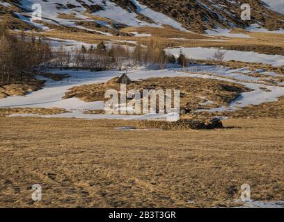Un vieux tracteur derrière une ruine de la tourbe maison en Islande Banque D'Images