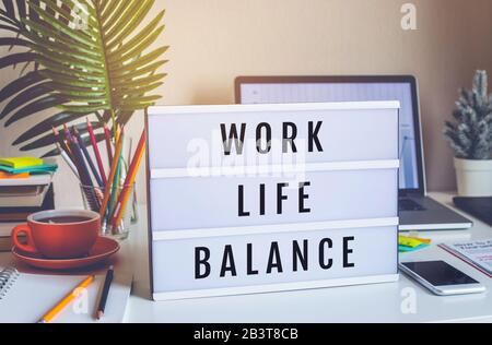 Concepts d'équilibre de la vie professionnelle avec texte sur la case de lumière sur la table de bureau dans le bureau à domicile.émotion positive au succès.corps sain Banque D'Images