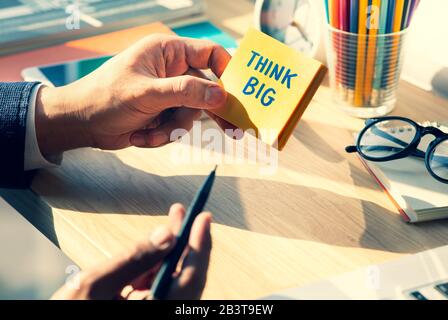 Pensez aux concepts grands et de créativité avec la jeune personne écrivant le texte sur notepaper.business but-plan-action.motivation du succès Banque D'Images