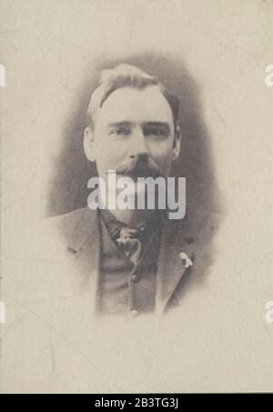 Un portrait d'une jeune homme de style édouardien ou victorienne dans un ancien studio de photographie. Banque D'Images