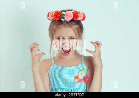 Frustré. Gros plan fille très fâchée hurlant dans l'horreur, sombre portrait. Jeune enfant stressé ayant une panne nerveuse isolé vert clair backgroun Banque D'Images