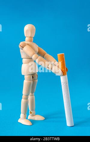 mégole en bois tenant une cigarette. Concept d'habitudes malsaines. Banque D'Images