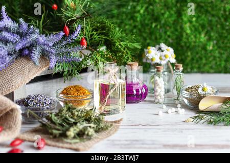 Variété d'herbes et de mélanges de plantes comme concept de médecine alternative sur fond de table en bois sur herbe verte. Traitement de l'homéopathie. Banque D'Images