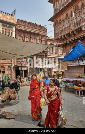 Les femmes des saris aux couleurs vives se promènent dans les rues de Bikaner avec Havelis typique, Rajasthan, Inde Banque D'Images