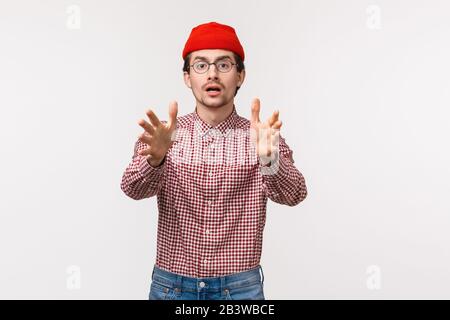 Portrait de taille-up de concerné et inquiet joli barbu gars atteignant les mains vers l'appareil photo comme essayer de prendre quelqu'un de tomber, avertir attention, regarder Banque D'Images