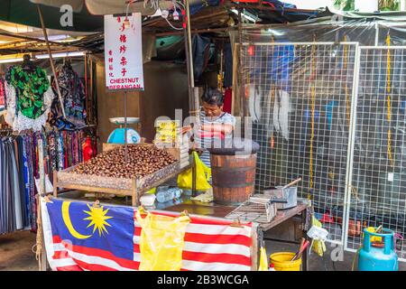 Homme local vendant des châtaignes rôties dans le marché de la rue Chinatown, Kuala lumpur, Malaisie, Asie Banque D'Images