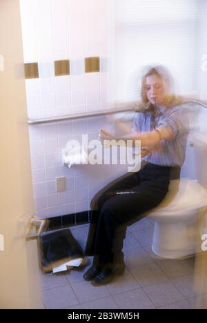 Austin Texas USA, 1988: Jeune femme blanche pousses de l'héroïne dans la salle de bains de bureau. M. ©Bob Daemmrich Banque D'Images