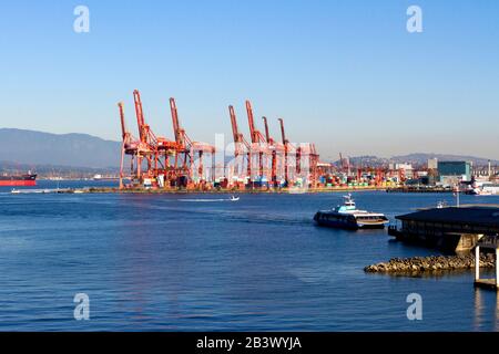 Grues à portique au terminal de conteneurs de Port Metro Vancouver, à Burrard Inlet, à Vancouver, en Colombie-Britannique, au Canada et au SeaBus, arrivant au terminal riverain Banque D'Images