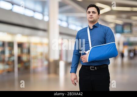 Homme Avec Bras Cassé Dans Le Terminal De L'Aéroport Banque D'Images