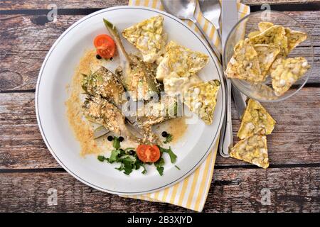 gratin di carciofi al forno con piatto italiano di formaggi Banque D'Images