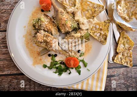 gratin di carciofi al forno con piatto italiano di formaggi Banque D'Images