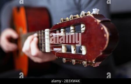 la main du guitariste se serre les doigts sur les accords d'une guitare acoustique. Banque D'Images