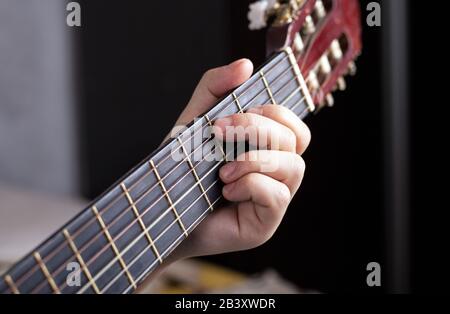 la main du guitariste se serre les doigts sur les accords d'une guitare acoustique. Banque D'Images