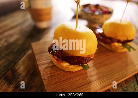 Deux petits sandwichs à glissière de hamburger sur planche en bois avec fond rustique de plan d'examen Banque D'Images