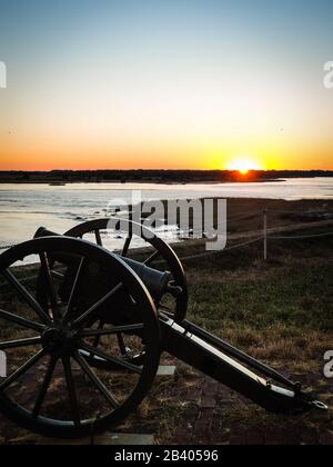 Canon historique de guerre civile sur l'île de fort Sumter près de Charleston, Caroline du Sud avant beau coucher de soleil orange. Aucune personne visible, copyspace. Banque D'Images