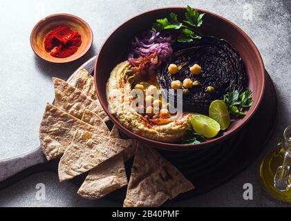 un bol de houmous, de chou violet cuit et d'oignon rouge mariné avec une tortilla et du paprika fumé Banque D'Images